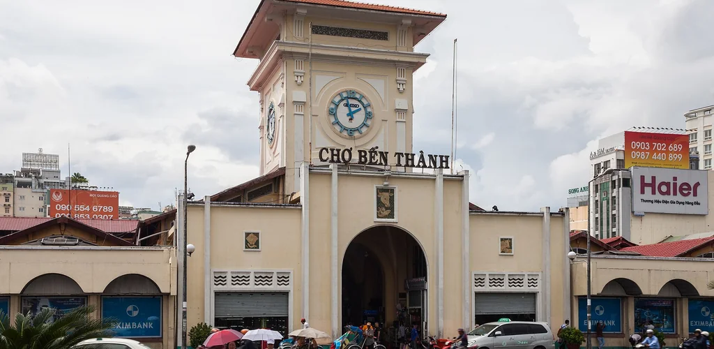 Pale yellow facade and clock tower of Ben Thanh Market, Ho Chi Minh City