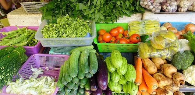 Fresh vegetables in plastic baskets at a produce stall in Ben Thanh Market